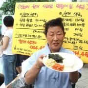 An activist presenting a meal to the media as part of a campaign